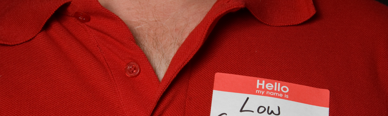 A person wearing a red shirt has a name tag that reads, “Hello my name is Low Self Esteem”.