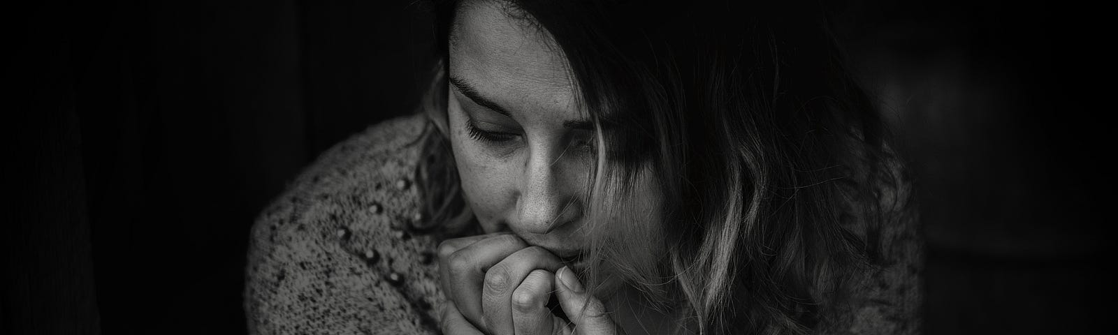 Greyscale Photography of Woman Wearing Long-sleeved Top and Biting Her Nails