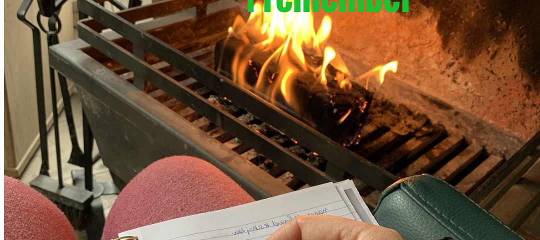 Photo of someone sitting by the fireplace with a notebook and pen in hand.