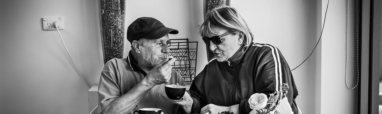 An older Italian couple sitting in a cafe eating pastries and drinking coffee, having fun. These are Stefani’s grandparents.