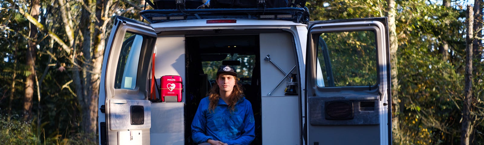 Thomas Meade sits in the back of a white search and rescue van in a parking lot.