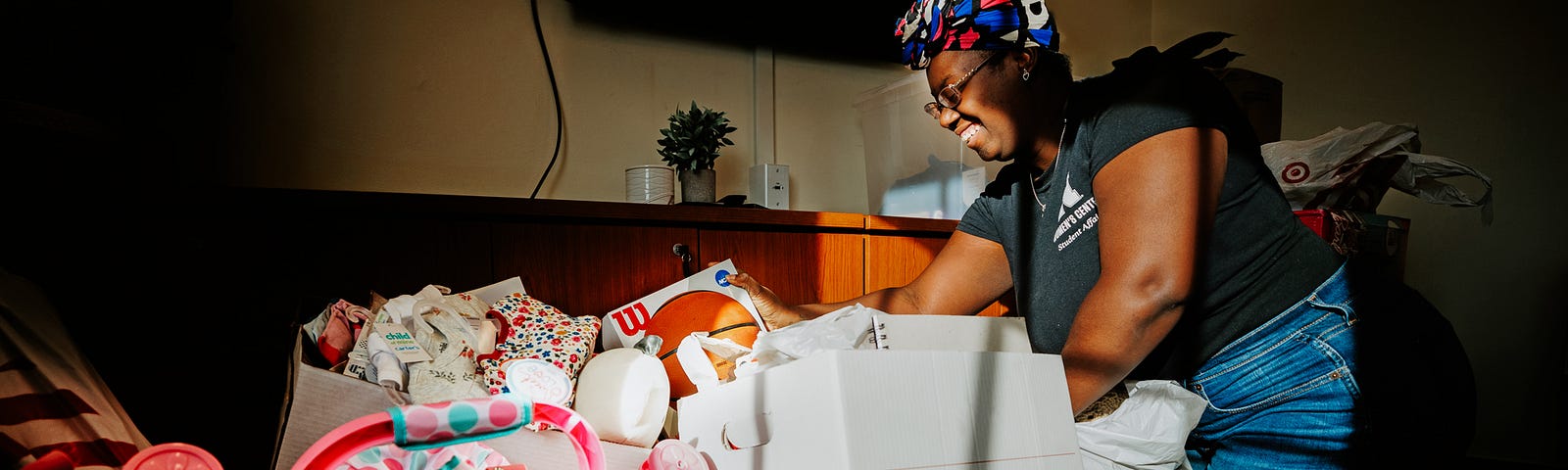 Domonique Cudjo, Assistant Director, Women’s Center, sorts Holiday for Little Huskers gifts in the center’s conference room.