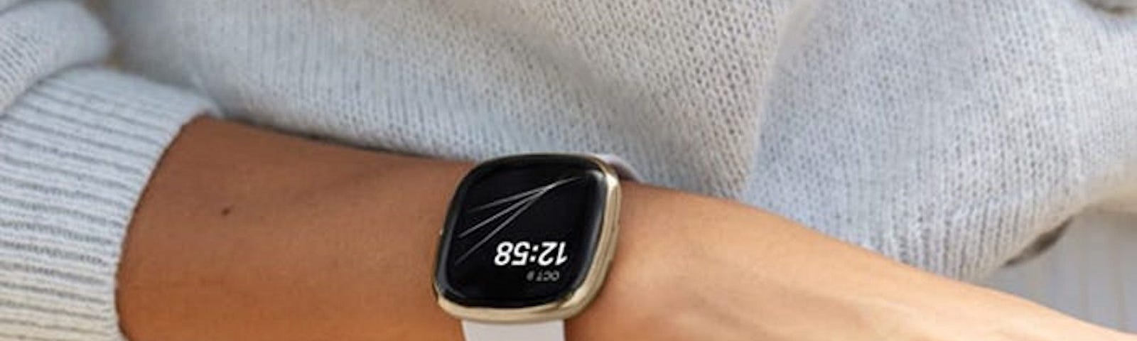 A person wearing a Fitbit on their wrist.