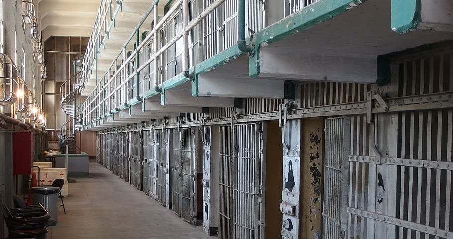 A photograph of a two-story row of empty jail cells.