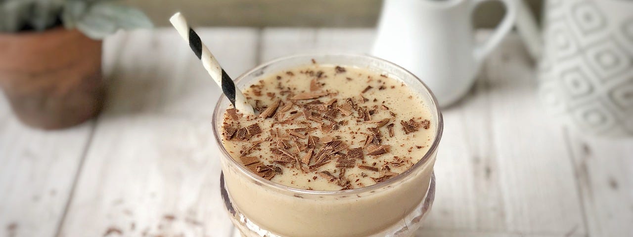 A cup of protein shake in a white table.