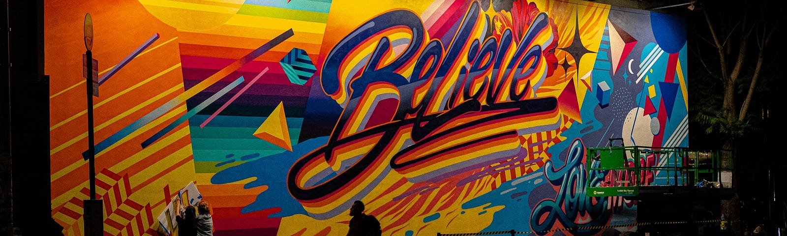 Colorful, urban mural on the street with word, “Believe”.