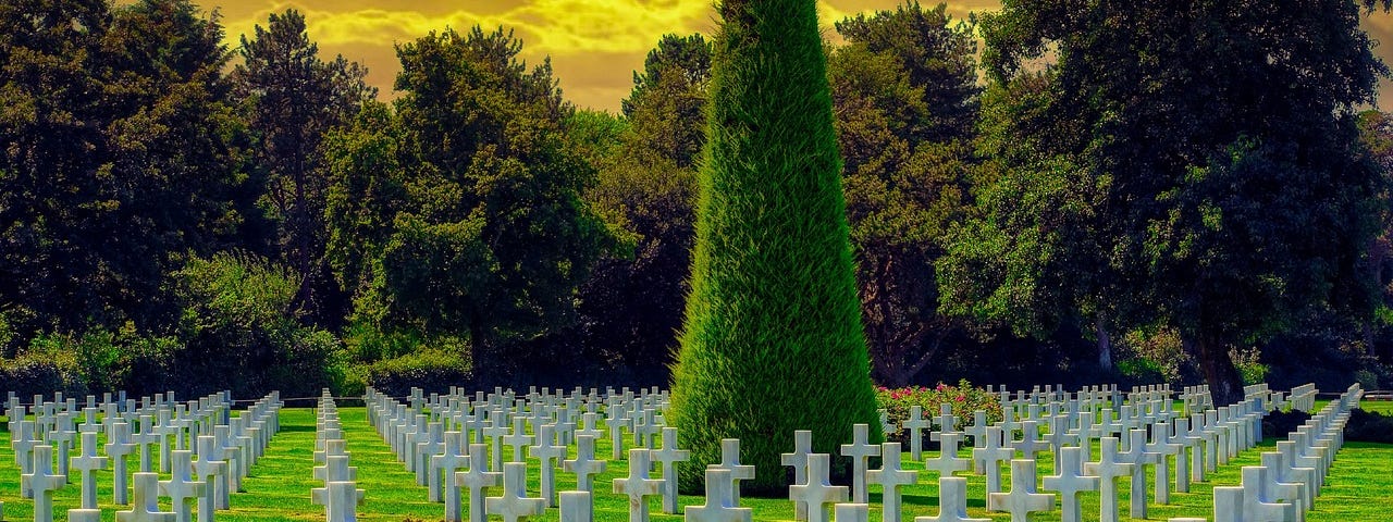 Cemetary with green lawn and white crosses, and an odd yellow sky