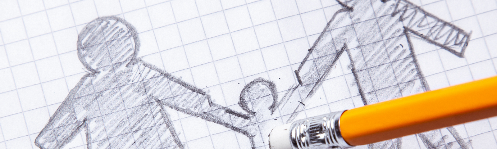 Stick figure drawings on graph paper of two parents holding the hands of a child who is being erased.