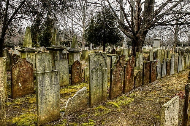 An old graveyard with three rows of faded gravestones