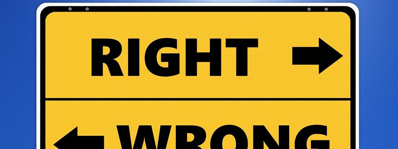 IMAGE: A bright yellow traffic sign with two arrows pointing in opposite directions, one saying “right” and the other saying “wrong”