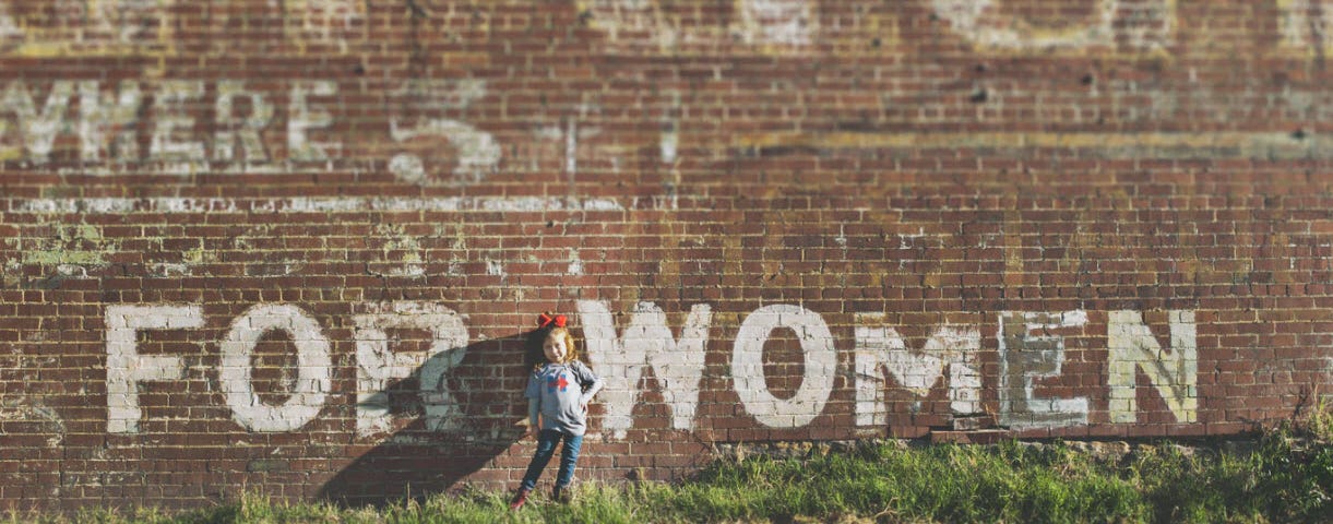 “FOR WOMEN” painted on brick wall | Image from Unsplash | Katherine Hanlon @tinymountain