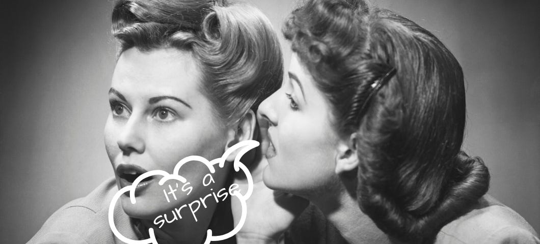 Black and white photo of one woman whispering into another woman’s ear, with the words “It’s a surprise!”