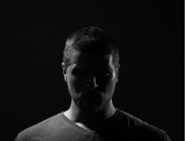 Sillouhette of a man against an ominous black background.