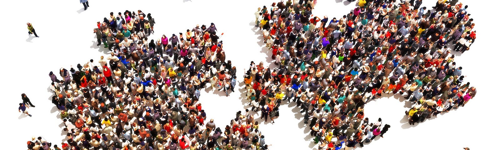 Many diverse people grouped together to form two puzzle pieces about to connect.