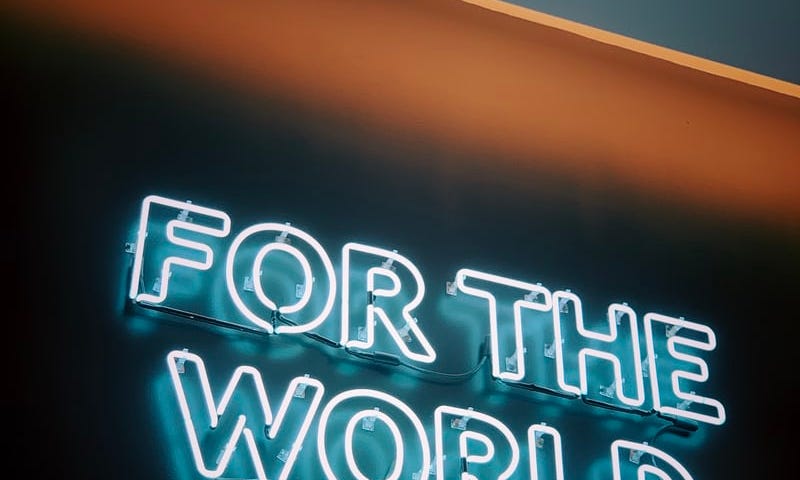 A neon sign that says FOR THE WORLD