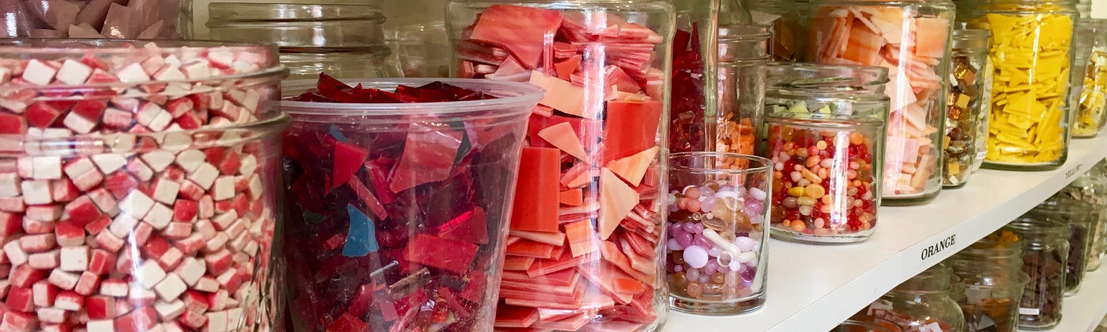 Jars of colored mosaic glass on shelves