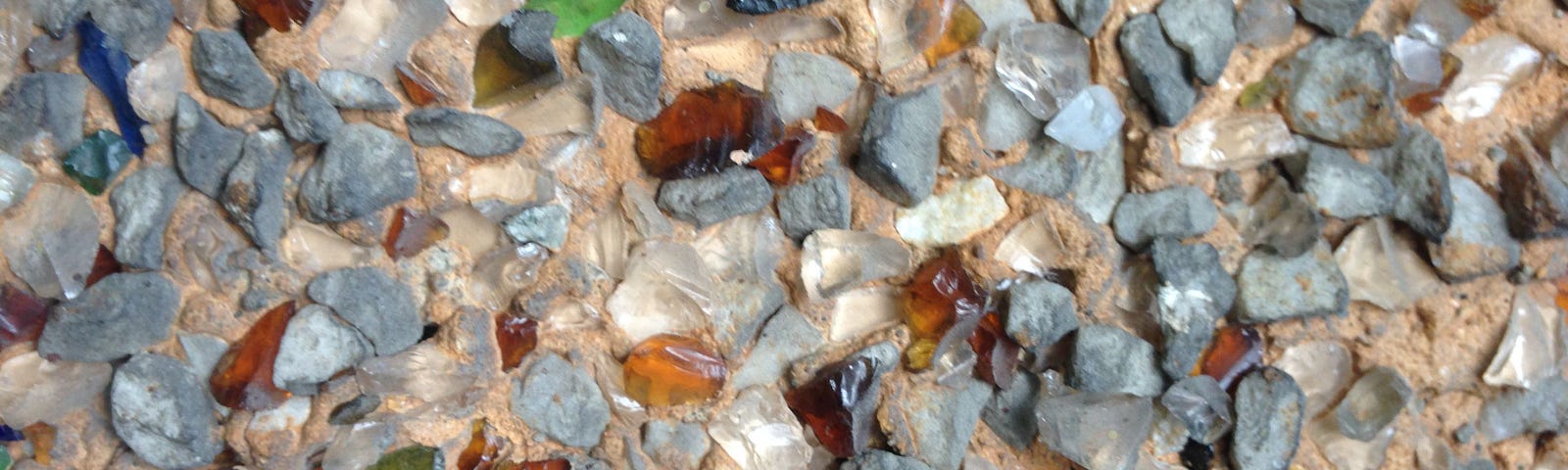 Closeup photo of “broken bottle” stucco with bits of colored glass, prominent on century-old homes in Vancouver, B.C.