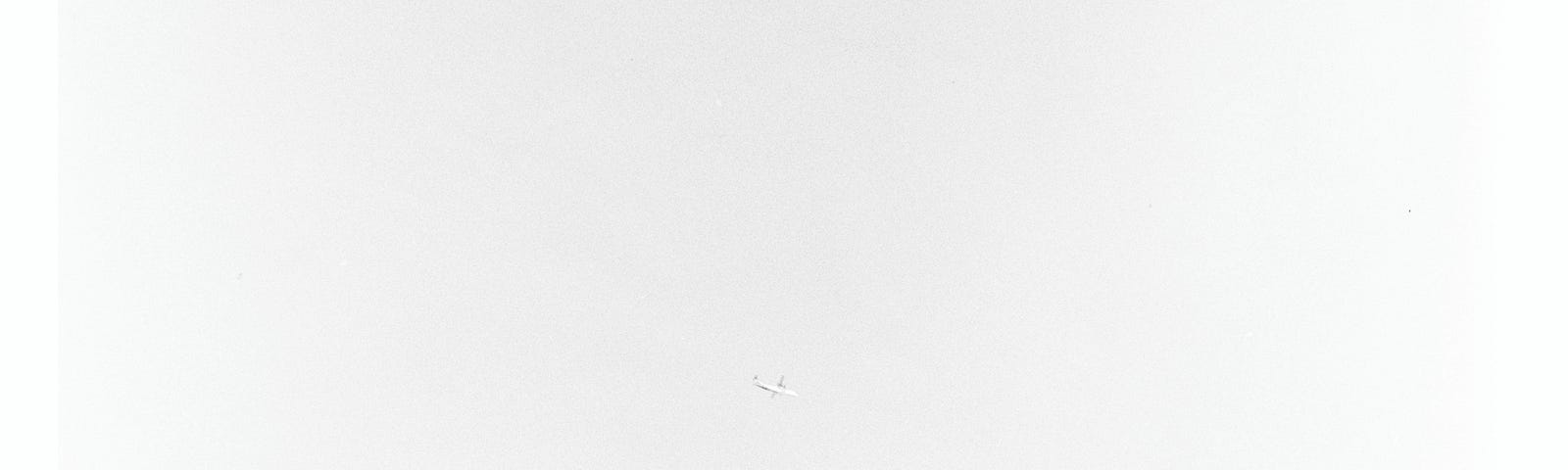 A black and white photo of an airliner on a grey sky