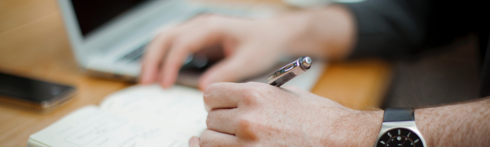 An image if a guy with a sweet, sweet watch journaling.