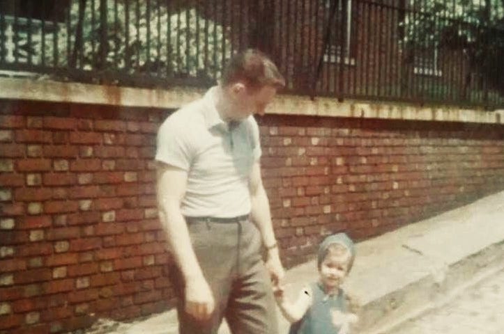 A young man walking his daughter across the street in the 1960’s Bronx