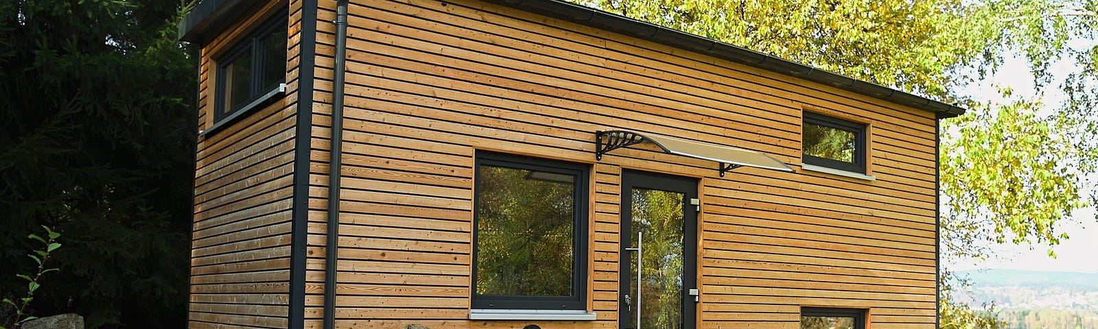 A couple sits in front of a tiny home.