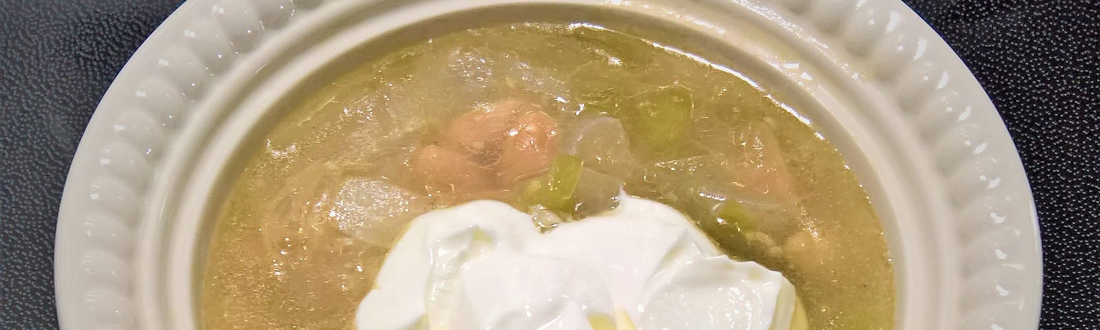 White Bean, Leek, and Tomatillo Soup garnished with Sour Cream