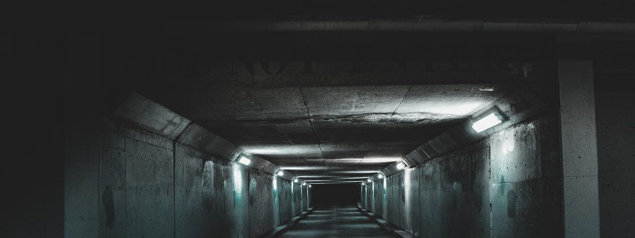 A dimly lit tunnel in a subway.