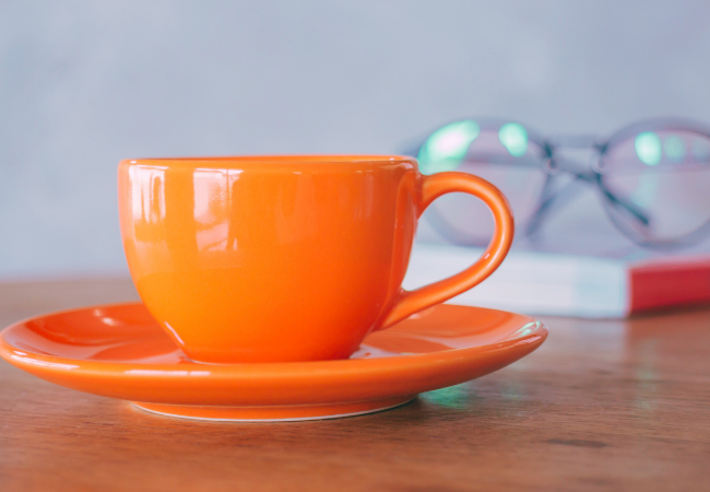 An orange coffee cup on the table