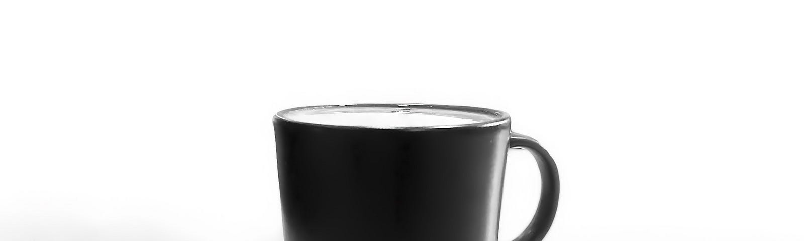 Image of a black mug on a white surface with blank background and a shadow in front of the mug.