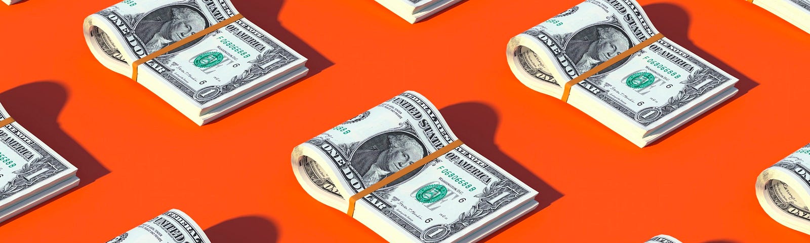 Multiple stacks of US 100 dollar bills neatly placed on a vibrant orange background, casting soft shadows, indicating wealth, savings, or financial concepts