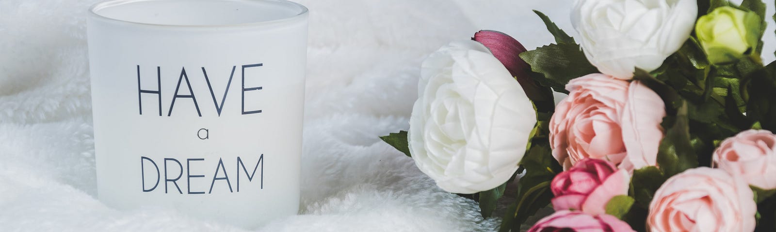 White and Pink Flowers Beside A Canister that reads: “Have a Dream”