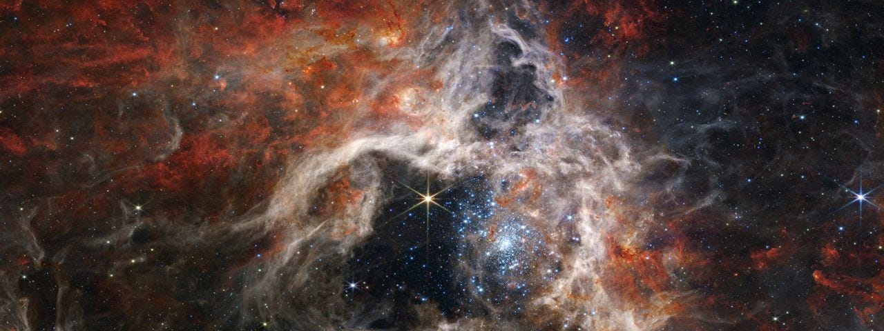 The James Webb Space Telescope reveals details of the structure and composition of the Tarantula Nebula, as well as dozens of background galaxies. Stellar nursery 30 Doradus gets its nickname of the Tarantula Nebula from its long, dusty filaments. Located in the Large Magellanic Cloud galaxy, it’s the largest and brightest star-forming region near our own galaxy, plus home to the hottest, most massive stars known.