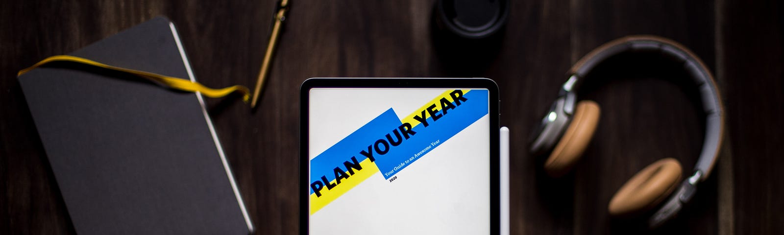 A journal, calendar, and headphones sitting on a table.