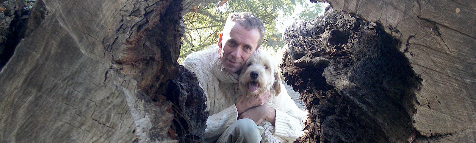 Karsten Ramser with his dog Delek looking through a hole in a tree. The gentleness of the image symbolises the transformation of depression into spiritual development.