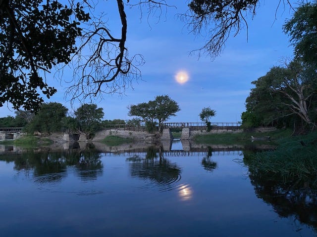 Full moon rising over a body of water in Maun, Botswana.