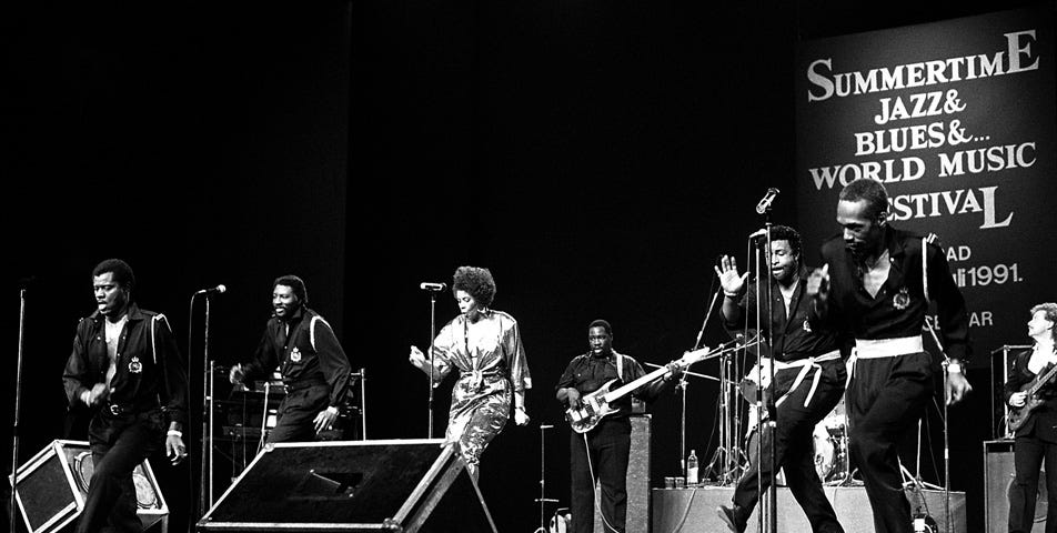 Black and white photo of the Temptations performing on stage.