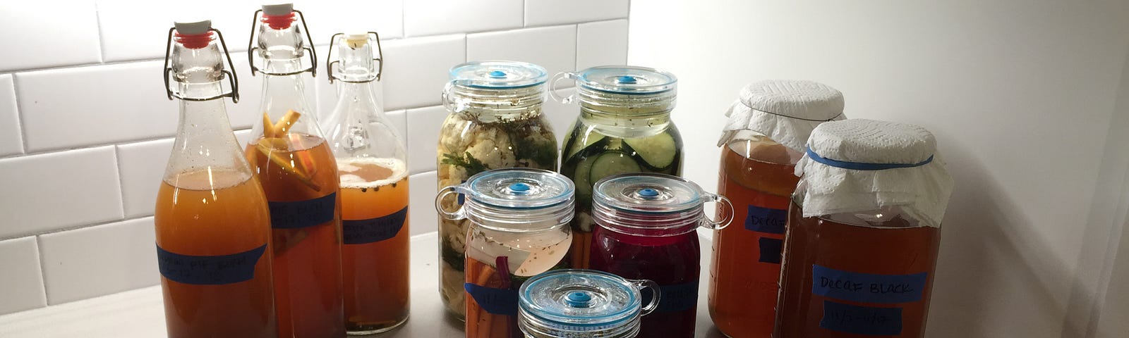 The pickle fleet in full force. Kombucha and pickled vegetables fermenting in jars.