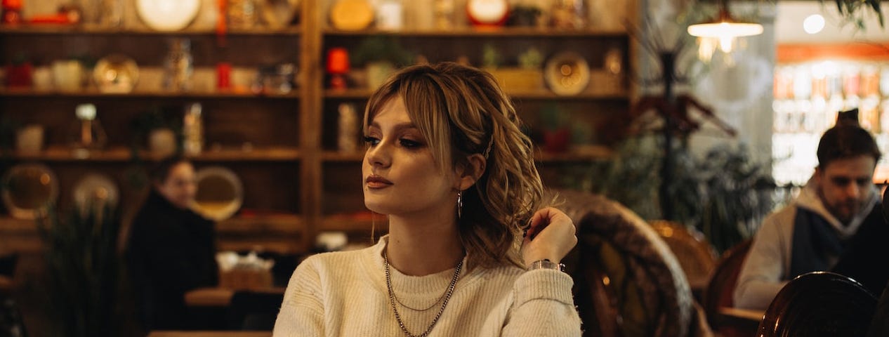 A cool-looking woman in a cafe (Photo by Vladyslav Tobolenko on Unsplash)