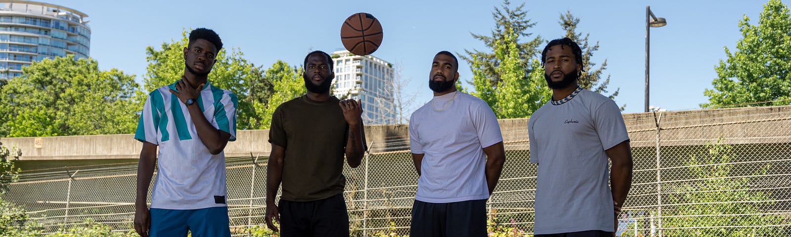 A group of black men at the park before playing basketball