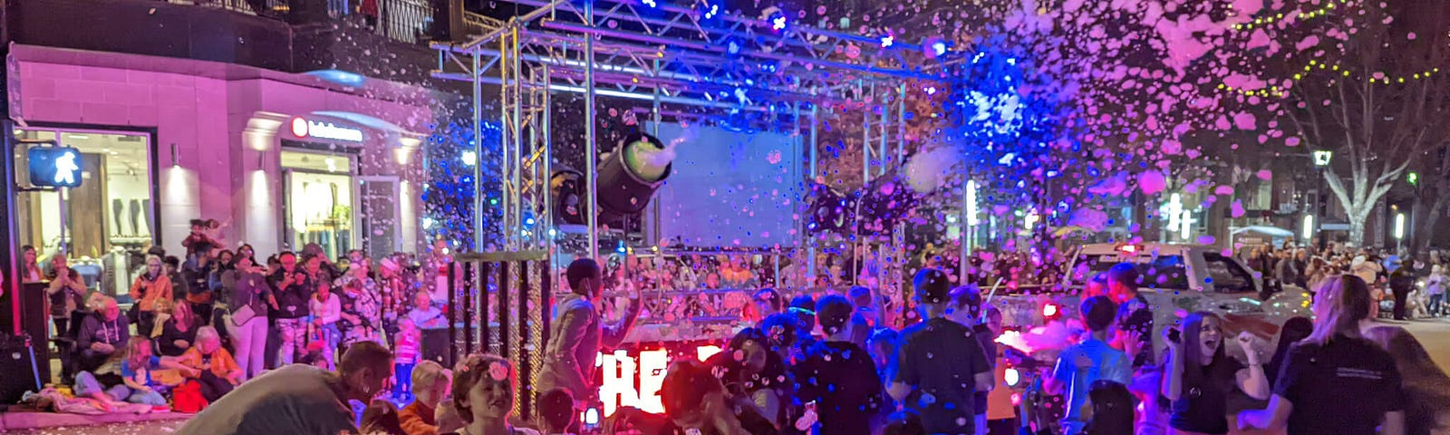 Colorful street scene with children playing in front of foam machine