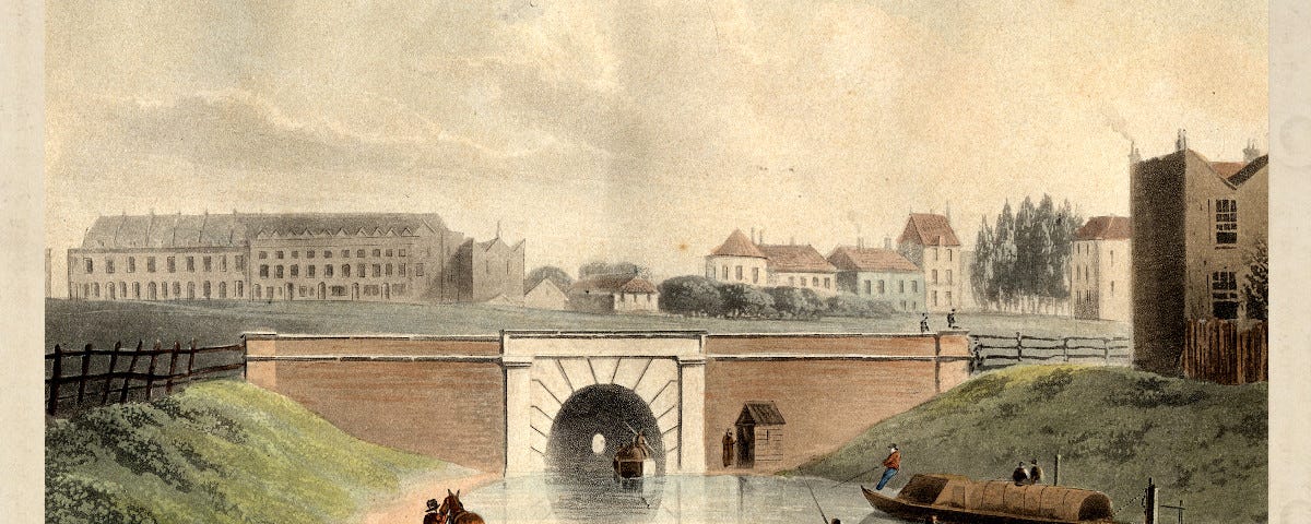 An 1822 aquatint print illustrating the west entrance to the recently built Regent’s Canal tunnel at Islington, north London. Two horse-drawn narrowboats can be seen on the canal, one about to enter and one leaving. The surrounding area is mainly fields, although a few large buildings can be seen.