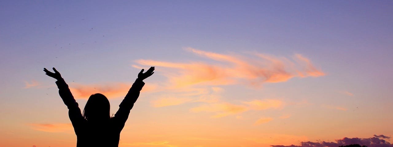 A Person standing with uplifted arms in praise