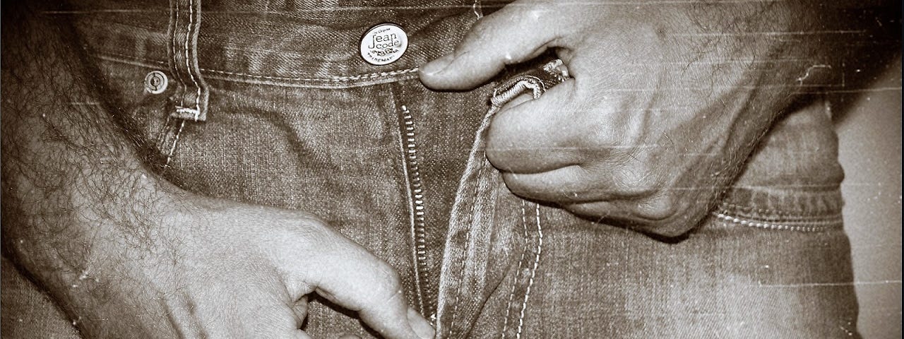 A man unzipping his jeans