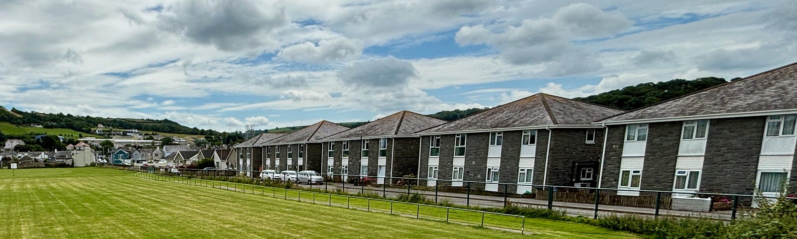 A row of houses next to an open field.