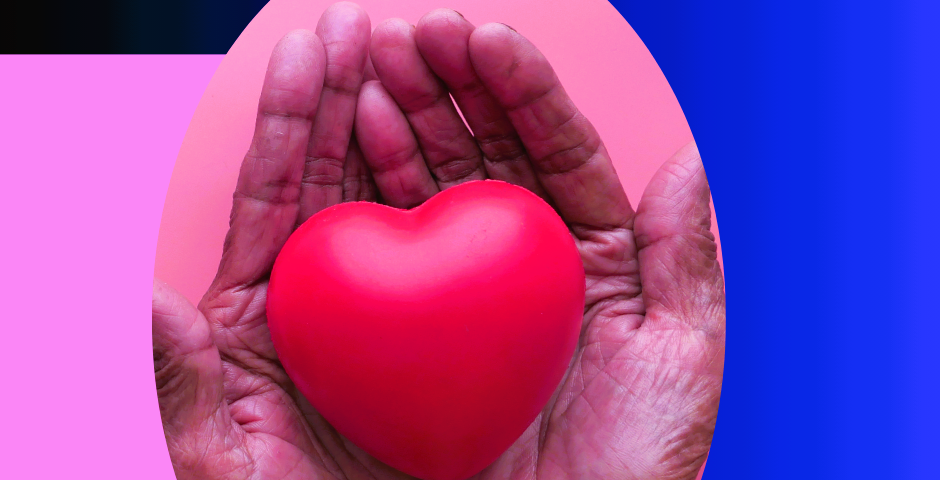 A pair of hands holding a red heart