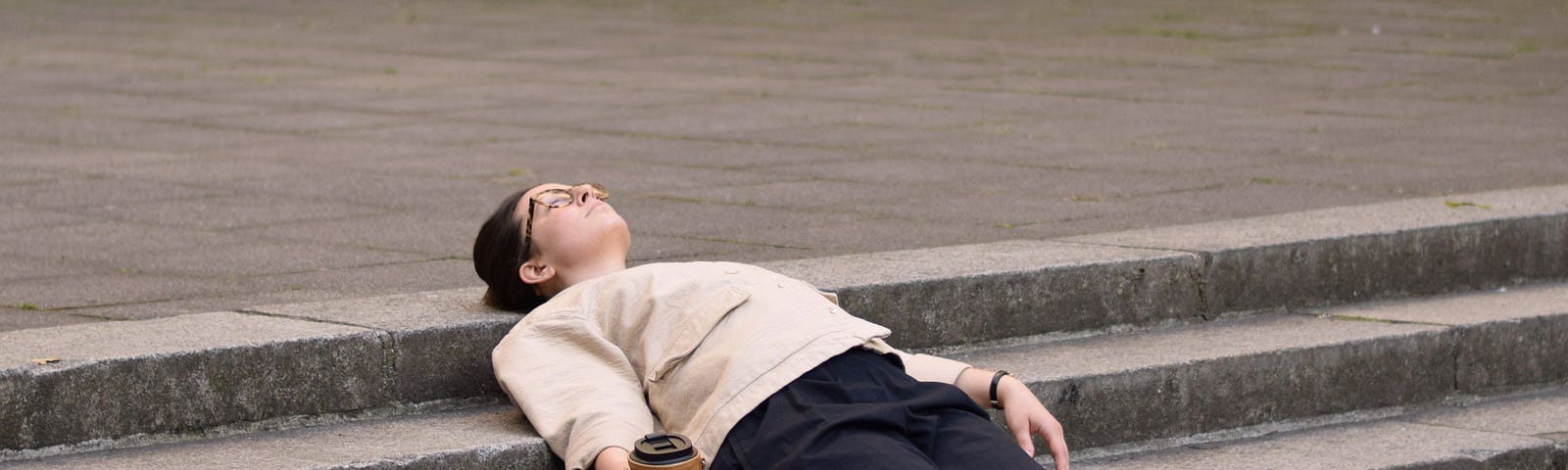 Woman with blue pants on lying on steps