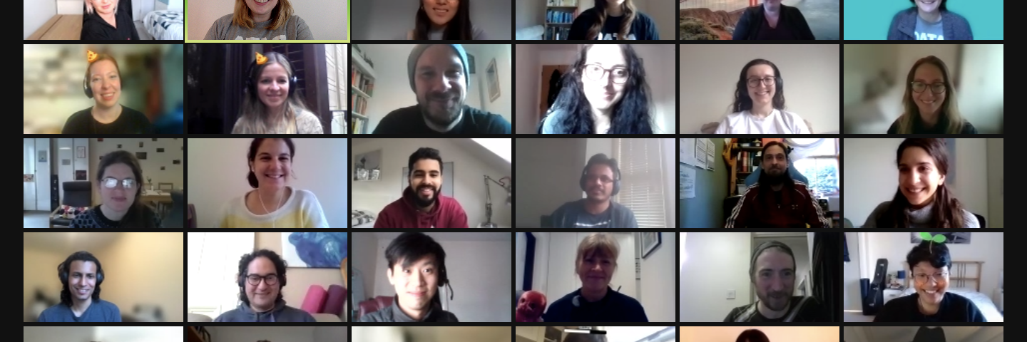 A Zoom screenshot of about 20 young adults smiling, all seated in their living rooms