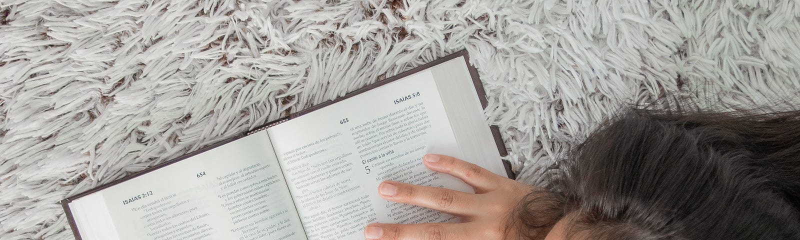 Woman asleep on a rug with an open Bible.