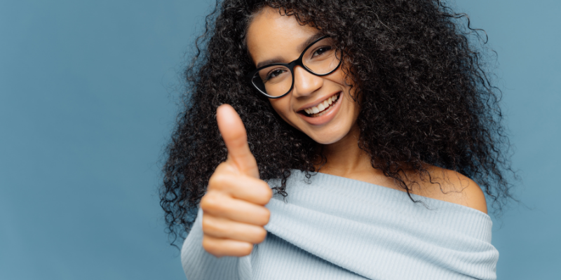 AA woman in glasses giving a thumb’s up gesture — How I Make $2,000 Per Month By Answering Simple Yes Or No Questions