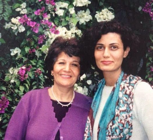 Dayya, and older woman, smiles with her adult daughter Rasha